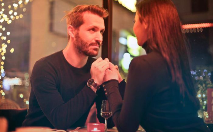 romantic-couple-holding-hands-together-during-a-romantic-dinner